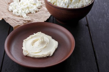 Peynir, taze peynir ve ekşi krema toprak, parşömen kağıt üzerinde keçi peyniri, rustik tarzı, sağlıklı gıda, ahşap bir zemin üzerine süt ürünleri alan, karanlık bir arka plan üzerinde süzme peynir kopyalamak minimalizm