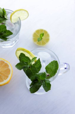 Mojito yaz tatili, buz beyaz bir arka planda, kireç ve limon, taze nane kokteyli, bir sanat, bir içki, minimalizm, bir tasarımcı için hazırlık yapmak için narenciye için yumuşak bir içki kokteyli