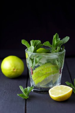 Minimalist kokteyl, mojito koyu arka plan, limon ve nane, yaz kokteyl serinletici içecek buz, vegan, kopya alanı, kokteyl, kutlama içmeye limon, taze nane ile tasarımcı için sanat boş