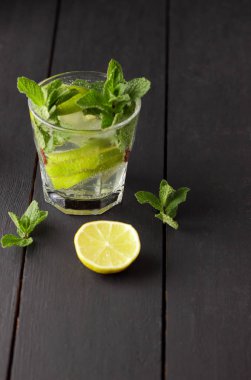 Minimalist kokteyl, mojito koyu arka plan, limon ve nane, yaz kokteyl serinletici içecek buz, vegan, kopya alanı, kokteyl, kutlama içmeye limon, taze nane ile tasarımcı için sanat boş