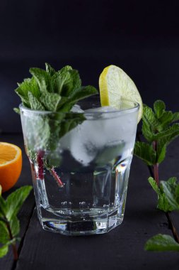 Mojito karanlık bir arka plan üzerinde yaz kokteyl limon ve nane, limon ile serinletici içecek, buz, sanat kopya alanı, minimalist kokteyl kokteyl, kutlama içmeye taze nane
