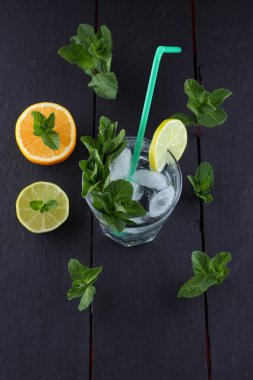 Mojito karanlık bir arka plan üzerinde yaz kokteyl limon ve nane, limon ile serinletici içecek, buz, sanat kopya alanı, minimalist kokteyl kokteyl, kutlama içmeye taze nane