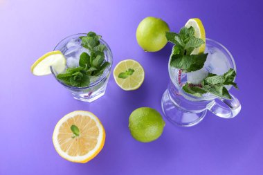 Mojito ultraviyole bir arka plan, nane, limon ve kireç, yaz dinlenmek için bir meşrubat, mor bir arka plan, bir pop sanat içki, yarım limon ve kireç, sanat bir kokteylde bir kokteyl