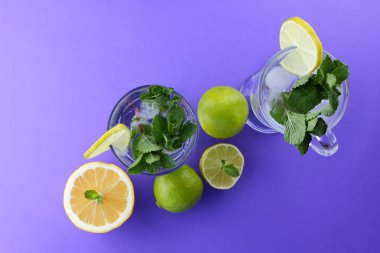 Mojito ultraviyole bir arka plan, nane, limon ve kireç, yaz dinlenmek için bir meşrubat, mor bir arka plan, bir pop sanat içki, yarım limon ve kireç, sanat bir kokteylde bir kokteyl