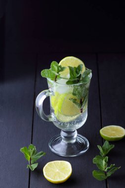 Karanlık bir arka plan üzerinde Mojito, limon ve nane, yaz kokteyl serinletici içecek içmeye kokteyl, minimalist kokteyl, kutlama buz, vegan, kopya alanı, limon, taze nane ile tasarımcı için boş