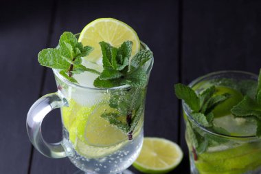 Karanlık bir arka plan üzerinde Mojito, limon ve nane, yaz kokteyl serinletici içecek içmeye kokteyl, minimalist kokteyl, kutlama buz, vegan, kopya alanı, limon, taze nane ile tasarımcı için boş