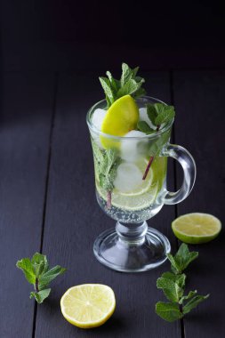 Karanlık bir arka plan üzerinde Mojito, limon ve nane, yaz kokteyl serinletici içecek içmeye kokteyl, minimalist kokteyl, kutlama buz, vegan, kopya alanı, limon, taze nane ile tasarımcı için boş