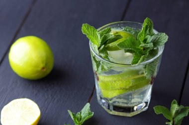 Karanlık bir arka plan üzerinde Mojito, limon ve nane, yaz kokteyl serinletici içecek içmeye kokteyl, minimalist kokteyl, kutlama buz, vegan, kopya alanı, limon, taze nane ile tasarımcı için boş