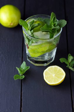Karanlık bir arka plan üzerinde Mojito, limon ve nane, yaz kokteyl serinletici içecek içmeye kokteyl, minimalist kokteyl, kutlama buz, vegan, kopya alanı, limon, taze nane ile tasarımcı için boş