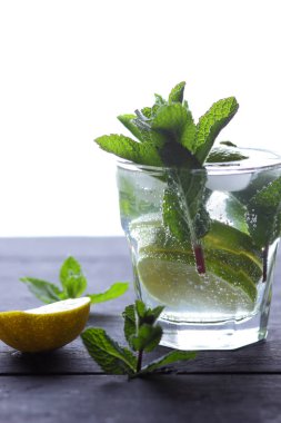 Karanlık bir arka plan üzerinde Mojito, limon ve nane, yaz kokteyl serinletici içecek içmeye kokteyl, minimalist kokteyl, kutlama buz, vegan, kopya alanı, limon, taze nane ile tasarımcı için boş