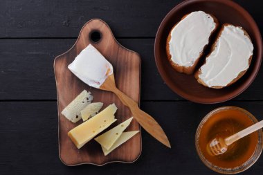 Ahşap oyun tahtası, sert peynir sandviç ile peynir, bal cam yemekleri, kopya alanı, minimalizm, peynir desen, ahşap koyu arka plan, sağlıklı gıda, ahşap çatal bıçak takımı