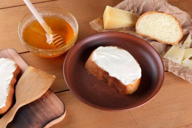 Ahşap oyun tahtası, parşömen kağıt, gıda sert peynir yumuşak peynir ile bal cam yemekleri, kopya alanı, peynir desen, ahşap arka plan, ahşap çatal bıçak takımı, basit gıda sandviç.