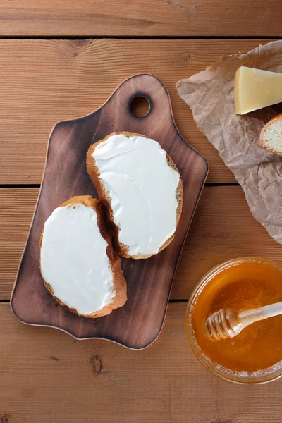 Ahşap oyun tahtası, parşömen kağıt, gıda sert peynir yumuşak peynir ile bal cam yemekleri, kopya alanı, peynir desen, ahşap arka plan, ahşap çatal bıçak takımı, basit gıda sandviç.