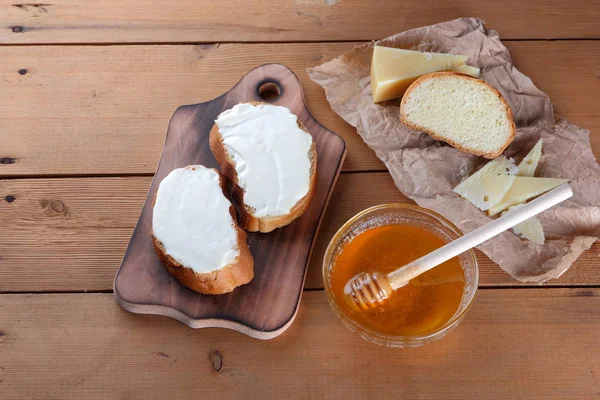 Ahşap oyun tahtası, parşömen kağıt, gıda sert peynir yumuşak peynir ile bal cam yemekleri, kopya alanı, peynir desen, ahşap arka plan, ahşap çatal bıçak takımı, basit gıda sandviç.