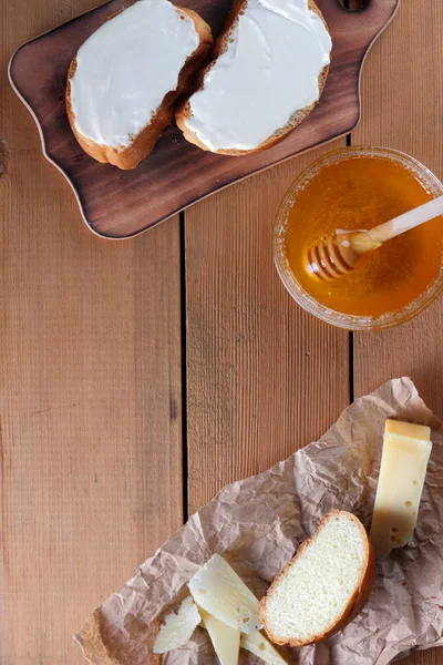 Ahşap oyun tahtası, parşömen kağıt, gıda sert peynir yumuşak peynir ile bal cam yemekleri, kopya alanı, peynir desen, ahşap arka plan, ahşap çatal bıçak takımı, basit gıda sandviç.