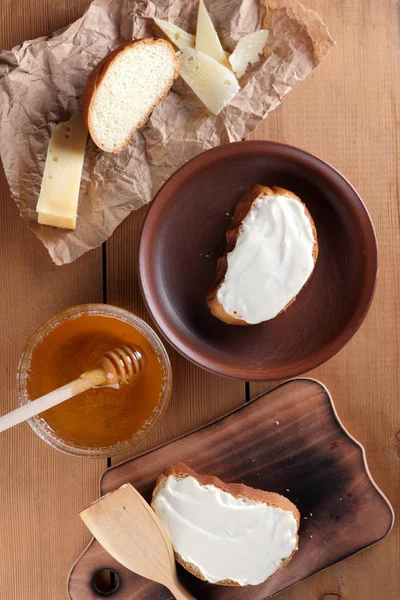 Ahşap oyun tahtası, parşömen kağıt, gıda sert peynir yumuşak peynir ile bal cam yemekleri, kopya alanı, peynir desen, ahşap arka plan, ahşap çatal bıçak takımı, basit gıda sandviç.