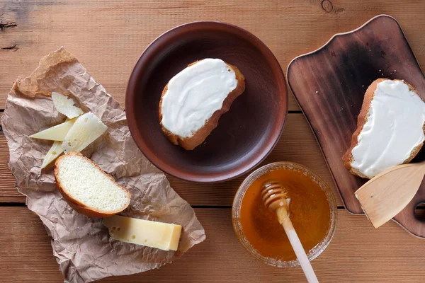 Ahşap oyun tahtası, parşömen kağıt, gıda sert peynir yumuşak peynir ile bal cam yemekleri, kopya alanı, peynir desen, ahşap arka plan, ahşap çatal bıçak takımı, basit gıda sandviç.