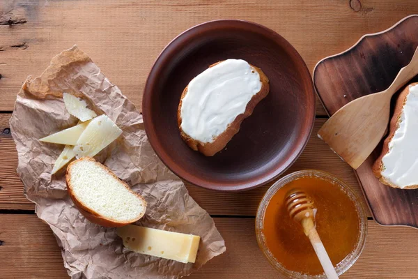 Ahşap oyun tahtası, parşömen kağıt, gıda sert peynir yumuşak peynir ile bal cam yemekleri, kopya alanı, peynir desen, ahşap arka plan, ahşap çatal bıçak takımı, basit gıda sandviç.