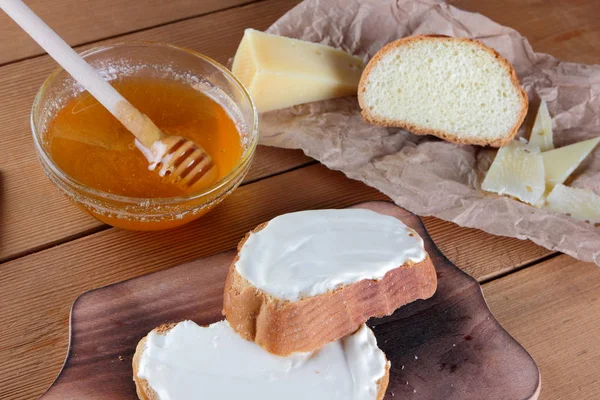 Ahşap oyun tahtası, parşömen kağıt, gıda sert peynir yumuşak peynir ile bal cam yemekleri, kopya alanı, peynir desen, ahşap arka plan, ahşap çatal bıçak takımı, basit gıda sandviç.