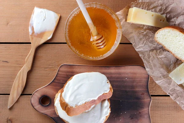 Ahşap oyun tahtası, parşömen kağıt, gıda sert peynir yumuşak peynir ile bal cam yemekleri, kopya alanı, peynir desen, ahşap arka plan, ahşap çatal bıçak takımı, basit gıda sandviç.