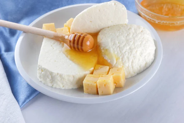 チーズ 白い背景 白チーズ 青ナプキン 木製の背景 平面図 白い皿にチーズ ガラス ポップアートでケフィアの木製の棒の上に蜂蜜ミルク品揃え — ストック写真