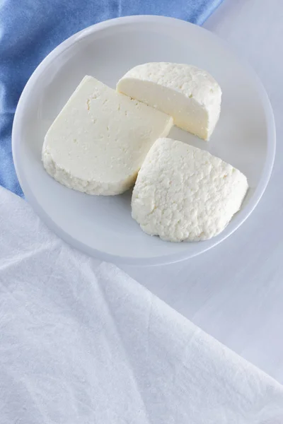 チーズの白い背景 白い皿の上の柔らかいチーズ ヨーグルト ミニマリズム コピーのガラス空間 白青ナプキン フランスの朝食 和食の乳製品 — ストック写真