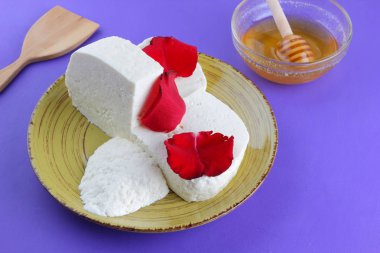 Peynir ve bal, yaprakları kırmızı gül, Yunan peynir bir mor arka plan, sarı bir plaka üzerinde beyaz peynir, minimalizm, tarzında süt ürünleri kopyalama alanı, Festival gıda, süt Kahvaltı, ultraviyole, tatlım