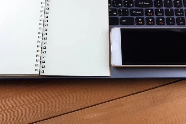 Bir dizüstü bilgisayar ve bir fincan kahve ahşap arka plan üzerinde bir iş istasyonu üzerinde eski bir Resepsiyon, bir smartphone ve bir defter, kalem ve gözlük işyeri, alan bir kopyasını, minimalist tarzı tasarımcı bir iş istasyonu