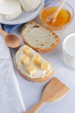 Peynir ve bal bir beyaz tabak, kefir ve yumuşak peynir, minimalizm, bal ve bir parça ekmek mavi gelmedi sandviçle, Fransız beyaz bir arka plan üzerinde Amerikan mutfağı Servis Kahvaltı