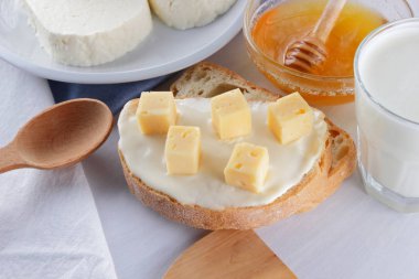 Peynir ve bal bir beyaz tabak, kefir ve yumuşak peynir, minimalizm, bal ve bir parça ekmek mavi gelmedi sandviçle, Fransız beyaz bir arka plan üzerinde Amerikan mutfağı Servis Kahvaltı