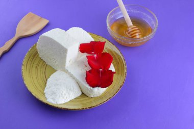 Peynir ve bal, yaprakları kırmızı gül, Yunan peynir bir mor arka plan, sarı bir plaka üzerinde beyaz peynir, minimalizm, tarzında süt ürünleri kopyalama alanı, süt Kahvaltı, ultraviyole, tatlım, sanat