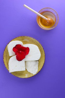 Peynir ve bal, yaprakları kırmızı gül, Yunan peynir bir mor arka plan, sarı bir plaka üzerinde beyaz peynir, minimalizm, tarzında süt ürünleri kopyalama alanı, süt Kahvaltı, ultraviyole, tatlım, sanat