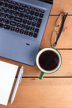 Kahve ahşap arka plan üzerinde eski bir Resepsiyon, smartphone ve bir dizüstü bilgisayar, iş istasyonunda bir dizüstü bilgisayar ve kalem ve işyeri, tasarımcı iş istasyonu, sanat gözlük
