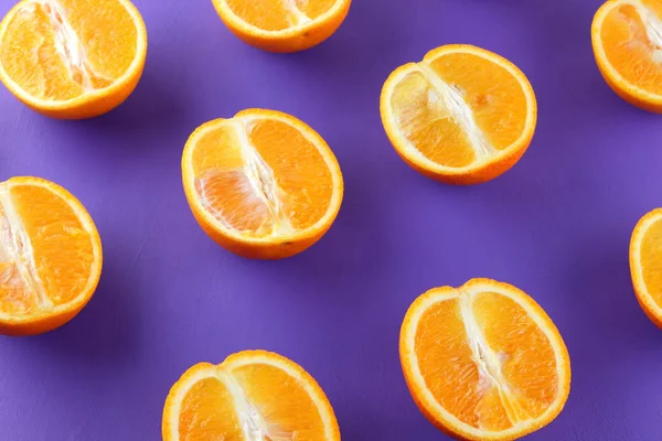 Sliced fruit oranges in checkered pattern on a purple background, symmetrically laid out citrus in pop art style, fruit pattern of halves of oranges, ultraviolet