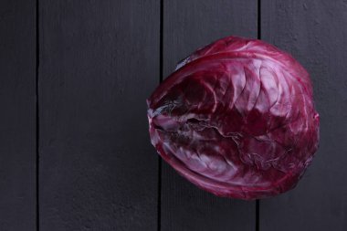 Mor lahana üzerinde koyu ahşap arka plan, karanlık, ahşap plakalar üzerinde bütün bir lahana mor sebze, vejetaryen yemek, kopya alanı, sebze minimalizm tarzı bir Üstten Görünüm