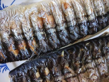 Uskumru üzerinde pişmiş ızgara, altın pişmiş kabuk, ev yapımı yemekler, siyah ızgara yüzeyi, Asya mutfağı, tatil tablo, retro tarzı yiyecek kızarmış balık ile balık