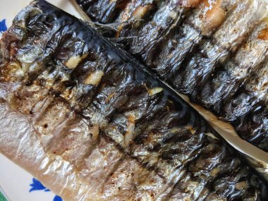 Uskumru üzerinde pişmiş ızgara, altın pişmiş kabuk, ev yapımı yemekler, siyah ızgara yüzeyi, Asya mutfağı, tatil tablo, retro tarzı yiyecek kızarmış balık ile balık