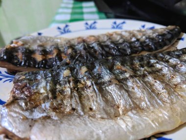 Uskumru üzerinde pişmiş ızgara, altın pişmiş kabuk, ev yapımı yemekler, siyah ızgara yüzeyi, Asya mutfağı, tatil tablo, retro tarzı yiyecek kızarmış balık ile balık