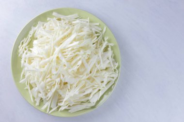 Beyaz zemin üzerine kıyılmış lahana, yeşil bir tabak, kopya alanı, üstten görünüm, sebzeli yemekler, taze sebze salatası, beyaz arka plan, minimalizm, Beyaz lahana izole