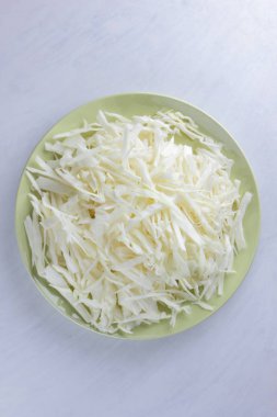 Beyaz zemin üzerine kıyılmış lahana, yeşil bir tabak, kopya alanı, üstten görünüm, sebzeli yemekler, taze sebze salatası, beyaz arka plan, minimalizm, Beyaz lahana izole