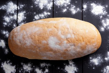 Ekmek kepekli ekmek karanlık panoları, hamur için bir tasarımcı, kopya alanı, rustik tarzı bir ocakta gelen siyah bir zemin üzerine un, un siyah bir arka plan üzerinde üstten görünüm, yemek