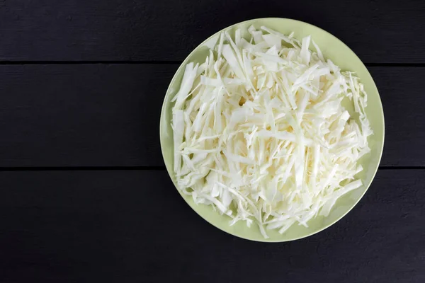 Gehakte Kool Een Zwarte Achtergrond Witte Kool Een Groene Plaat — Stockfoto