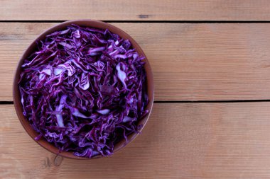 Ahşap arka plan, kırmızı lahana bir kil kase, kopya alanı, rustik tarzı, vejetaryen yemek, yarı taze lahana, minimalizm üzerinde kıyılmış mor lahana