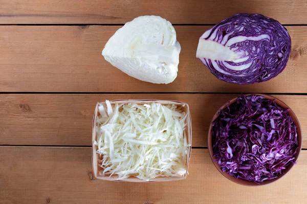 Assorted cabbage, chopped red cabbage and cabbage on a wooden background, vegetables in a clay bowl, a wooden box with vegetables, vegetarian food, wooden cutlery