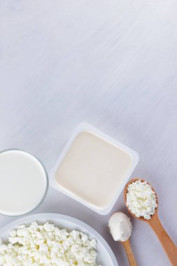 Bir beyaz tahta, süzme peynir, beyaz arka plan, bir bardak süt, peynir sandviç, ahşap çatal bıçak takımı, kopya alanı için krem ve yumuşak peynir süt ürünleri muhtelif