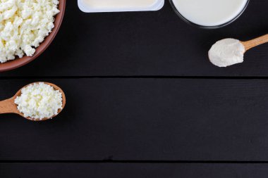 Doğal organik süt ürünleri koyu arka plan, süt, ekşi krema, peynir bir kil plaka, rustik tarzı, eski ahşap arka plan, üstten görünüm alanı Kopyala