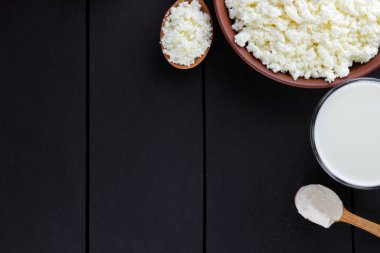 Doğal organik süt ürünleri koyu arka plan, süt, ekşi krema, peynir bir kil plaka, rustik tarzı, eski ahşap arka plan, üstten görünüm alanı Kopyala