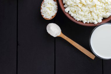 Doğal organik süt ürünleri koyu arka plan, süt, ekşi krema, peynir bir kil plaka, rustik tarzı, eski ahşap arka plan, üstten görünüm alanı Kopyala