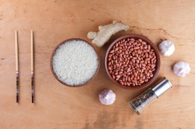 Çin Gıda katkı maddeleri, Kuruyemiş, sebze, zencefil kökü. Çin yemekleri tüm dünyada en popüler olanı. Çiğ pirinç ve baharat ahşap arka plan üzerinde. Sarımsak ve soğan yemek pişirmek için. Kopya alanı