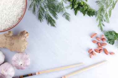 Çeşitli Asya vejetaryen yemek malzemeler. Kuruyemiş, sebze, zencefil kökü. Taze yeşillik, dereotu ve maydanoz. Pirinç, fıstık ve baharat beyaz zemin üzerinde. Kopya alanı
